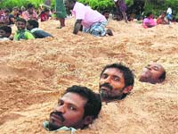 Nuclear Rage: People buried themselves in sand as they took part in a protest against Kudankulam nuclear plant (KKNPP) at village Kootapuli
