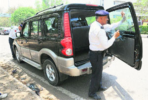A policeman removes a black film from a car at the Sector 20/30 light point in Chandigarh.