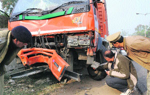 Officials inspect the truck that met with an accident at the Railway light point in Chandigarh. 