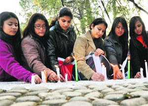 Girls light candles in memory of the Delhi gang rape victim in Dharamsala on Sunday. 