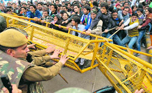 Protesters try to break a police barricade in New Delhi on Sunday. 