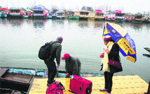 Tourists wait for a shikara ride at the Dal Lake in Srinagar on Sunday. 