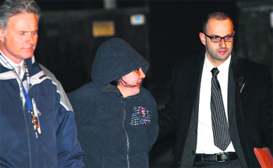 Police officers escort Erika Menendez to a waiting car in New York on Saturday.