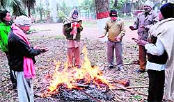 People stand by a bonfire on a chilly day in Amritsar on Monday