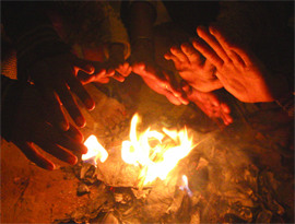 People try to warm themselves as temperature goes down in New Delhi on Monday.
