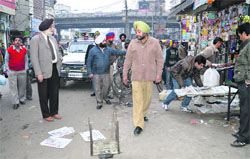 Mayor Harcharan Singh Gohalwaria gets encroachments removed near Clock Tower Chowk in Ludhiana on Monday. photo: inderjeet verma