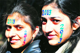 Girls paint their faces as they welcome 2013 in Shimla on Monday.