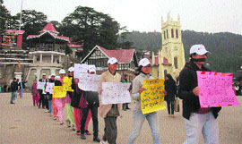 Residents hold placards and wear black ribbons during a silent protest against the Delhi gang rape in Shimla on Tuesday.