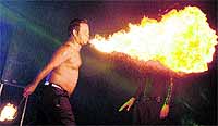 A performer blows out a fire ball