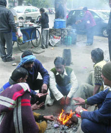 People sit around a bonfire at the roadside in New Delhi on Wednesday.