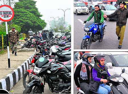 Motorcycles parked haphazardly on the main road outside the BSNL office ; an NCC cadet heklps police stop violators of traffic norms; a girl along with a pillion rider wear helmets as Jammu Traffic police celebrates the Traffic Safety Week in Jammu on Wednesday