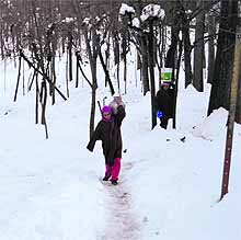 Kashmiri women carry drinking water, up against heavy snowfall in south Kashmir on Wednesday