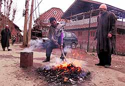 Residents burn firewood to make charcoal in Srinagar on Wednesday
