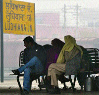 Braving chill and fog, passengers wait for their trains at the Ludhiana railway station on Wednesday. 