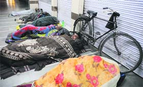 Daily wage earners sleep outside showrooms at Sector 35 in Chandigarh on Wednesday night.