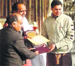 Prof Hare Krishnan Mahapatra, presents the Bal Puraskar to Basu Mohan, student of the Rashtriya Sanskrit Sansthan, at Naleti on Thursday. Photo: Ashok Raina