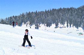 A young tourist skis down a slope in Gulmarg on Thursday.