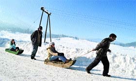 Tourists enjoy a ride on the sleigh at Gulmarg Resort, near Srinagar, on Thursday.