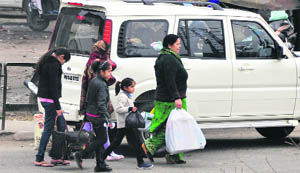 A family prepares to walk to its destination following the traffic jam on the NH-1 in Ludhiana on Thursday.