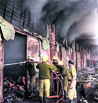 Fire personnel douse a fire that broke out in a godown at Burrabazar in Kolkata on Thursday