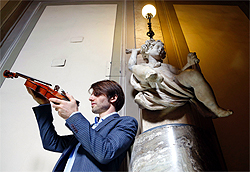French violin maker Mathias Menanteau is pictured as he inspects a violin in front of his workshop in downtown Rome, Italy, in this December 14, 2012, photo. Besides following the traditional techniques and methods used by eighteenth-century Italian violin makers to create his own bow instruments, Menanteau also adopts the less rigid, scientific approach of dendrochronology  the science of dating events and changes by observing annual growth rings in timber  when restoring these instruments in his workshop