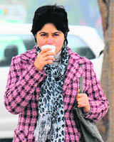 A woman sips a hot drink on a chilly Friday afternoon at Sector 17 in Chandigarh on Friday. 