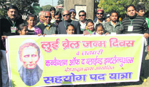 Visually impaired persons take out a march on the birth anniversary of Louis Braille in Dehradun on Friday. 