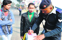 Two girls being challaned as part of a drive for not wearing helmet in Haridwar on Friday. Tribune photo: Rameshwar Gaur