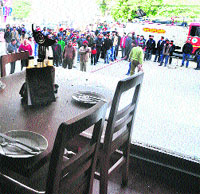 Onlookers stand outside the restaurant where the explosion took place at the Sarabha Nagar Market in Ludhiana on Friday