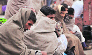 Passengers wait for trains that are running late by several hours in Ludhiana on Friday.