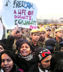 JNU students raise slogans demanding justice for the rape victim at Connaught Place in New Delhi on Friday.