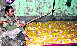 Zakir Hussain, a quilt maker, works at his shop at Jwalapur in Haridwar on Saturday