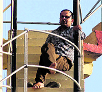 Vijay Pal Singh Rawat, a leader of Shiksha Bandhus, who climbed up a water tank in support of their demands, in Dehradun on Saturday.