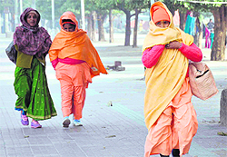 Women saints walk alongside the Ganga canal ghat braving winter chill in Haridwar on Saturday