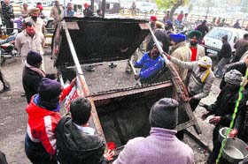 Officials of the tehbazaari wing of the MC remove an encroachment near Aarti Chowk in Ludhiana on Saturday.