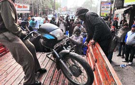 A wrongly parked motorcycle being confiscated near Aarti Chowk in Ludhiana on Saturday.
