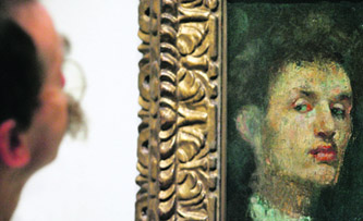 An art critic looks at Edvard Munch’s “Self portrait” (R) hanging in the Royal Academy of Arts in London in this file photo. He may be acclaimed in the art world and coveted by thieves but Edvard Munch is starved of recognition in his native Norway, where squabbles have delayed a museum worthy of his oeuvre.