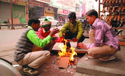 With the sun playing truant in this cold January, shopkeepers try to keep themselves warm by sitting around a bonfire in a city market. 