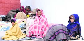 Patients attendants shiver in the open on the PGI campus in Chandigarh on Sunday. 