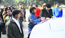 A member of a family, which accused the police of misbehaving with them, narrates the incident to a police official near Centra Mall in Chandigarh on Sunday. 