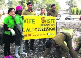Members of the Waste Warriors and policemen collect garbage in front of the office of the SSP in Dehradun on Sunday