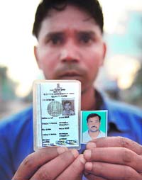 A relative shows a photograph of missing worker Jalandhar Chaudhari.