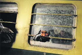 A man looks through a broken mirror on the Jaffar Express after an attack, in Quetta on Sunday