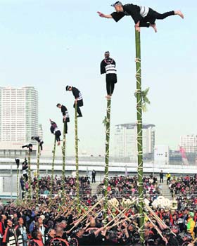 Members of a traditional firefighting preservation group perform on top of bamboo ladders during the annual New Years Fire Brigade Review in Tokyo on Sunday