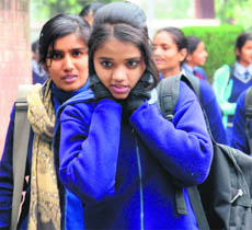 A girl covers her ears with her hands amid the biting cold in Chandigarh on Monday.