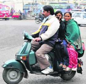 A scooterist takes two pillion riders despite the ongoing Road Safety Week in Jammu on Monday.