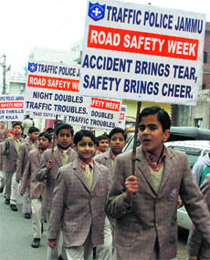 School students participate in an awareness rally during the road safety week in Jammu on Monday. 