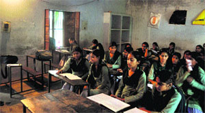Students sit in a low-lit classroom in Ludhiana. 