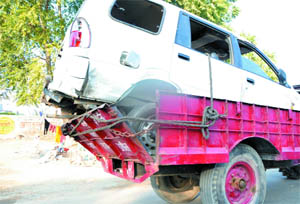 A tractor carries a vehicle damaged in road accident.