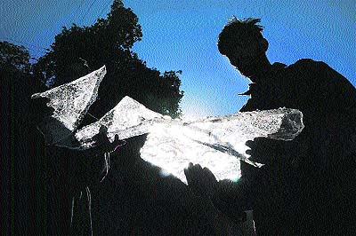 Two residents hold chunks of frozen water in their hands in Shimla on Tuesday. 